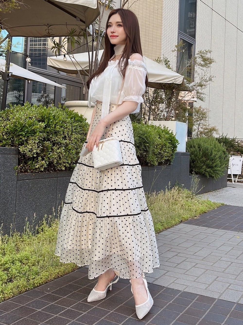 ホワイト系のスカート、ホワイト系のシャツ/ブラウス、ホワイト系のパンプスを着用したレディースの春コーディネートの2枚目の写真