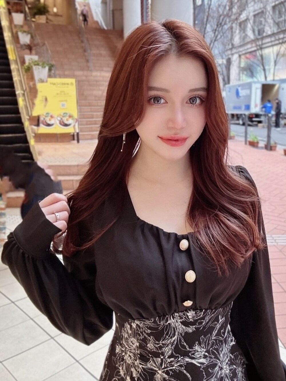 ブラック系のワンピース、ホワイト系のハンドバッグ、ホワイト系のパンプスを着用したレディースの冬コーディネートの3枚目の写真