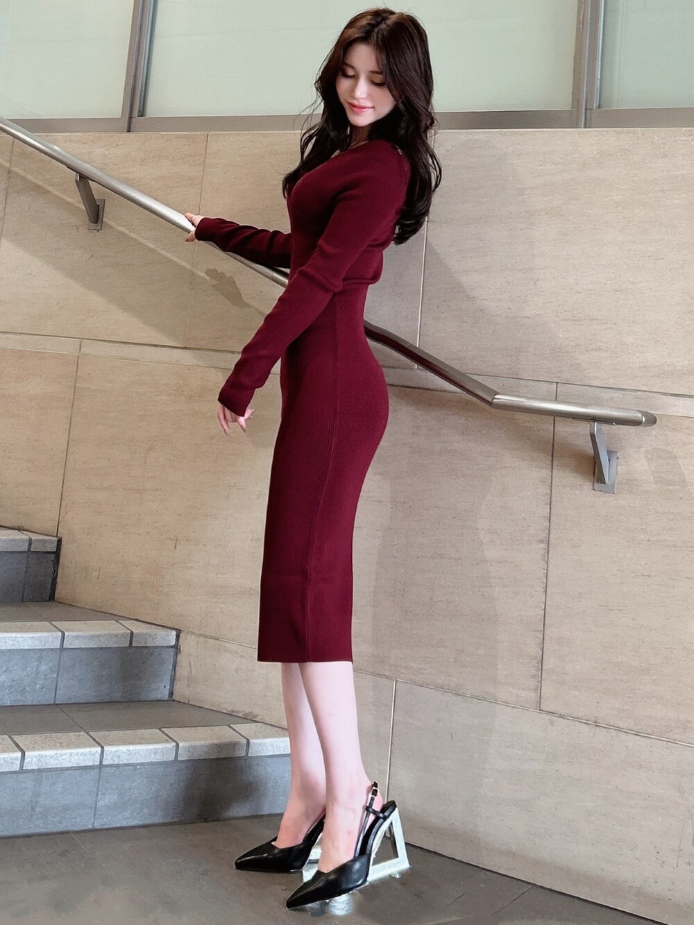 レッド系のワンピース、ブラック系のサンダルを着用したレディースの秋コーディネートの3枚目の写真