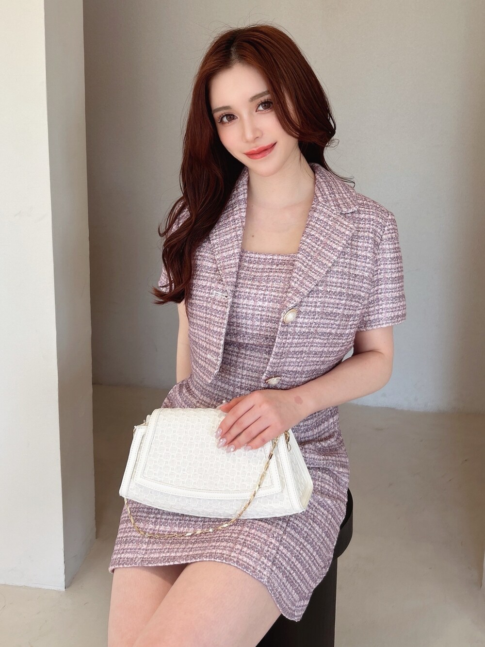 ピンク系のワンピース、ピンク系のテーラードジャケット、ホワイト系のパンプスを着用したレディースの春コーディネートの2枚目の写真