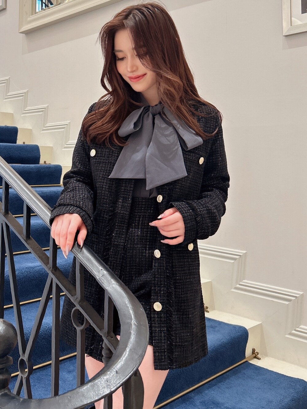 ブラック系のノーカラージャケット、ブラック系のその他パンツ、ブルー系のシャツ/ブラウスを着用したレディースの秋コーディネートの2枚目の写真