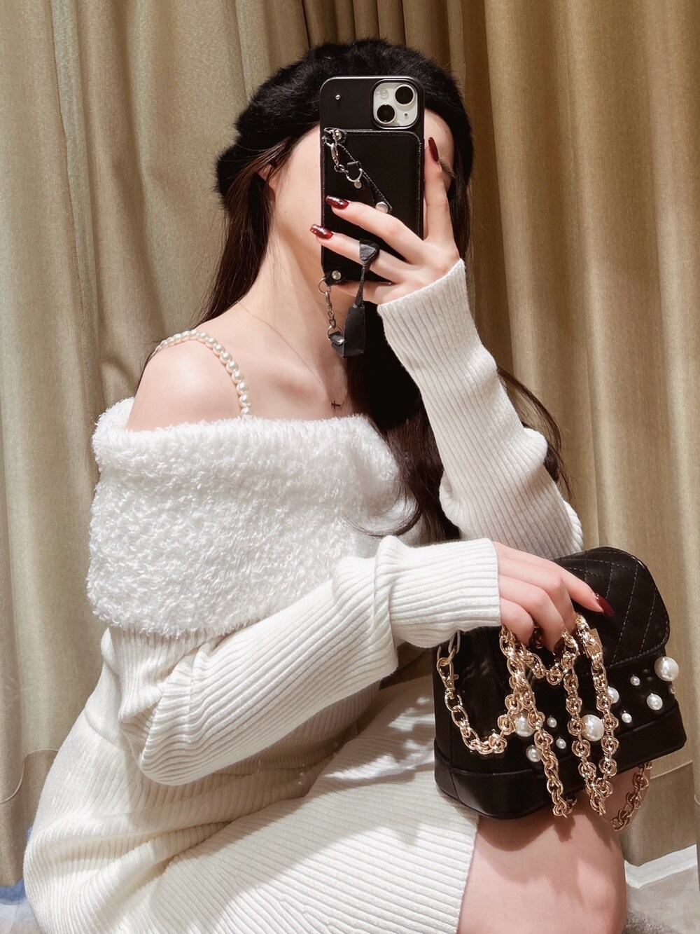 ホワイト系のワンピース、ブラック系のショルダーバッグ、ブラック系のブーツを着用したレディースの冬コーディネートの2枚目の写真