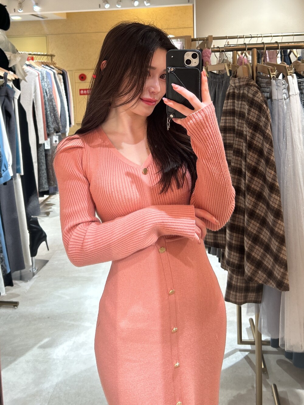 オレンジ系のワンピースを着用したレディースの冬コーディネートの2枚目の写真