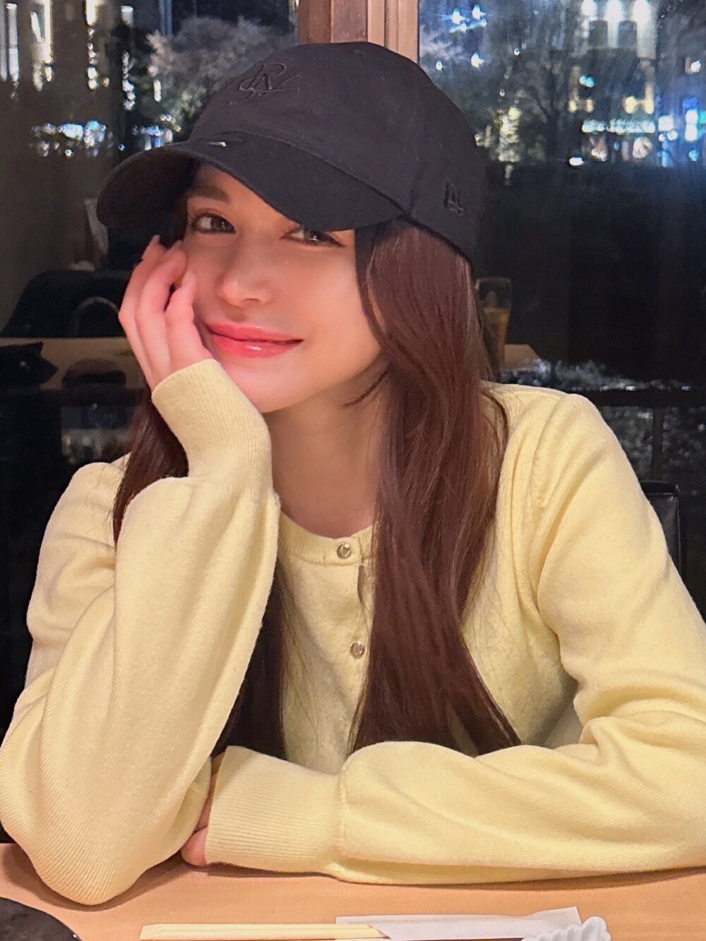 イエロー系のカーディガン/ボレロ、ブラック系のキャップを着用したレディースの春コーディネートの4枚目の写真