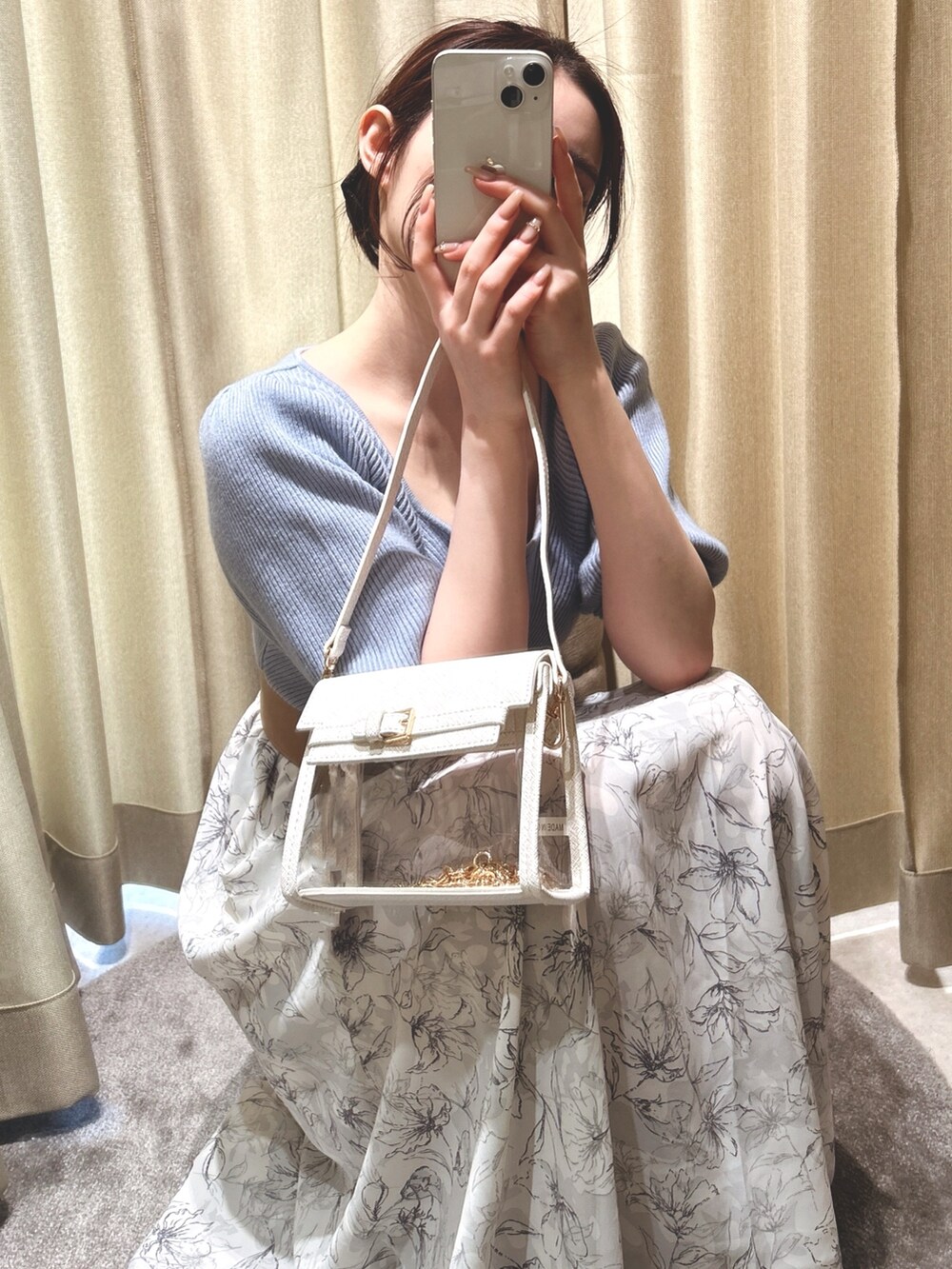 ブルー系のワンピース、ホワイト系のハンドバッグ、ベージュ系のパンプスを着用したレディースの春コーディネートの2枚目の写真