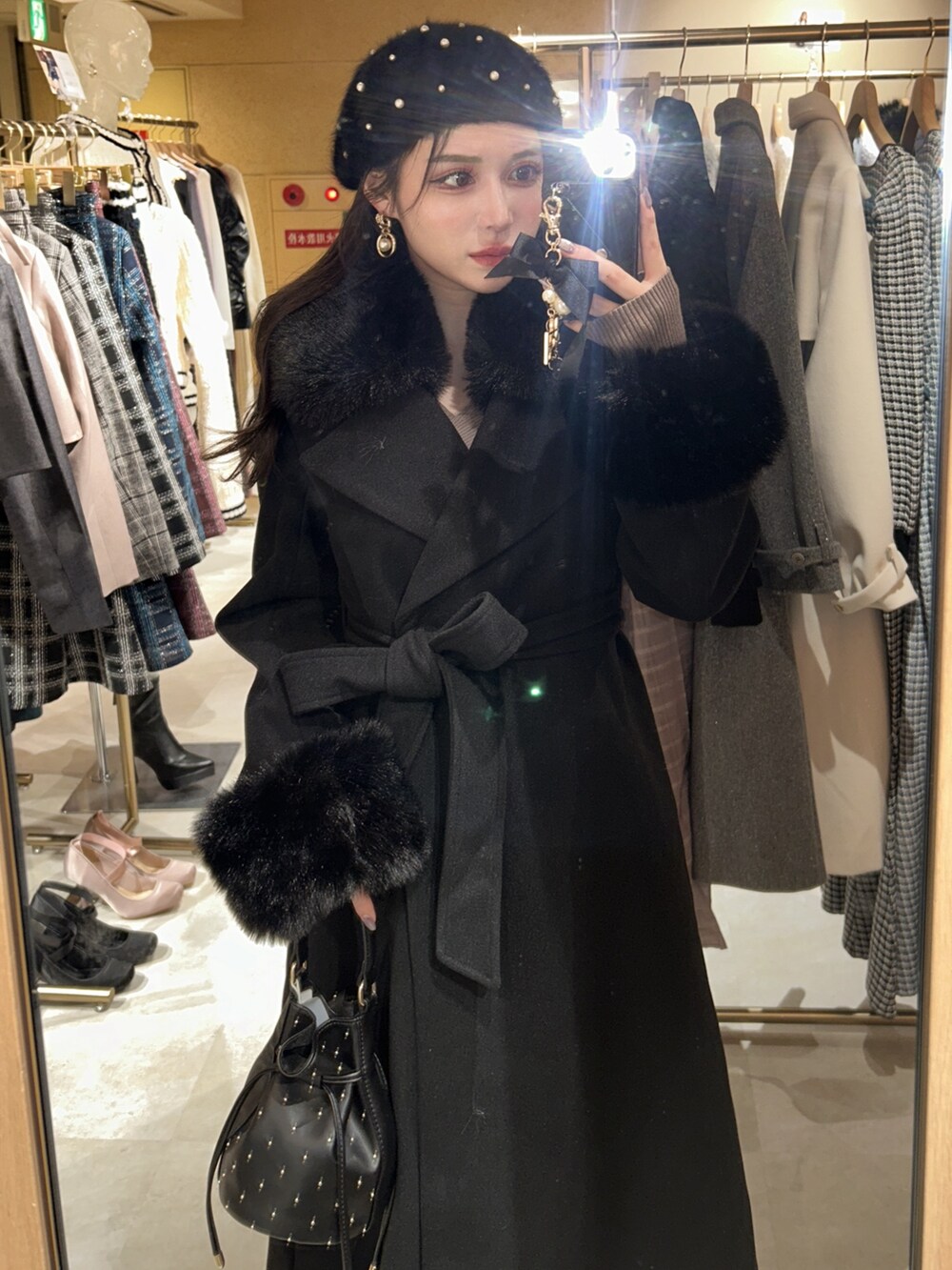 ブラック系のチェスターコート、ブラック系のハンチング/ベレー帽を着用したレディースの秋コーディネートの3枚目の写真