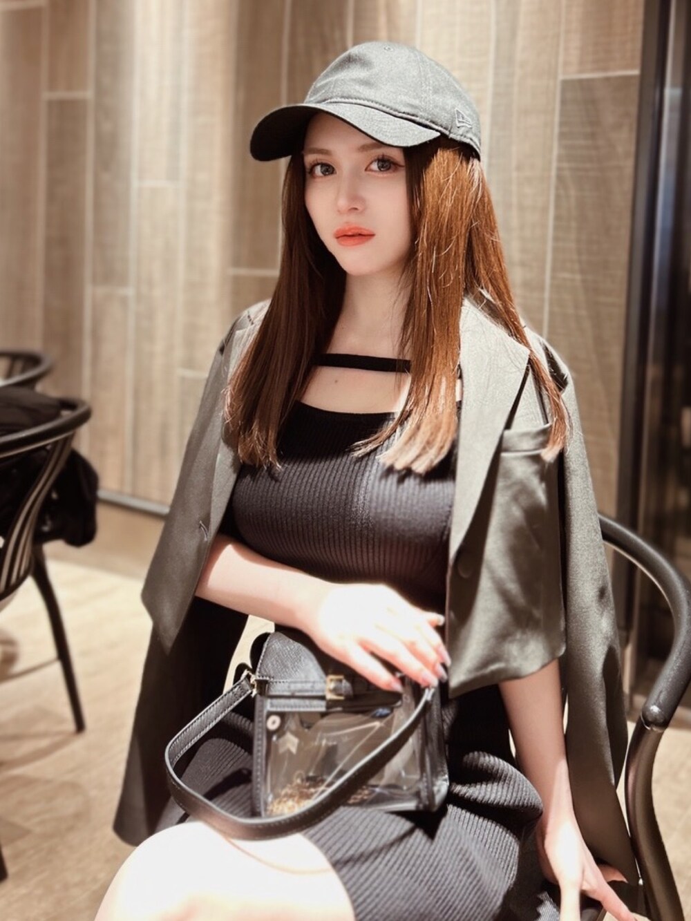 ブラック系のワンピース、ブラック系のハンドバッグ、ブラック系のキャップを着用したレディースの春コーディネートの2枚目の写真