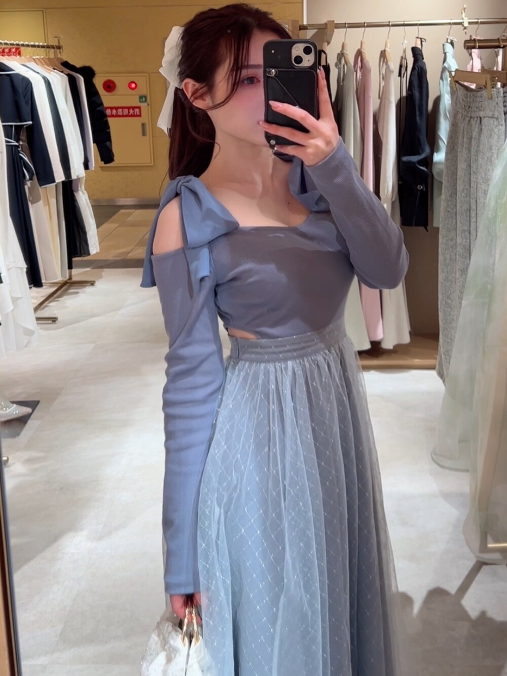 ブルー系のワンピース、ホワイト系のハンドバッグ、ホワイト系のバレッタ/ヘアクリップを着用したレディースの冬コーディネートの3枚目の写真