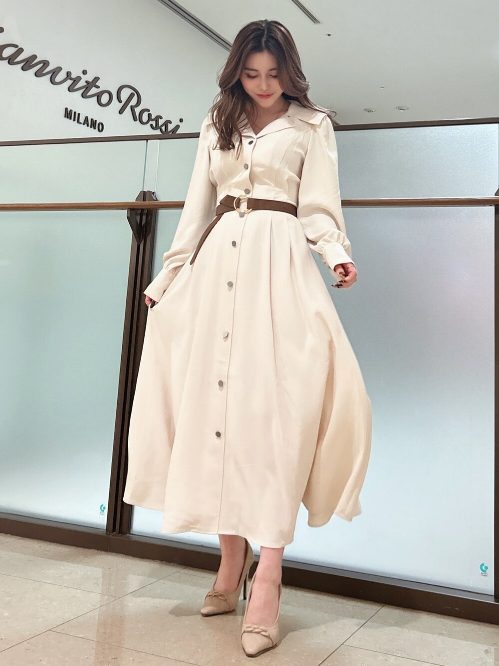 ベージュ系のワンピース、ベージュ系のパンプス、ブラウン系のベルトを着用したレディースの春コーディネートの2枚目の写真