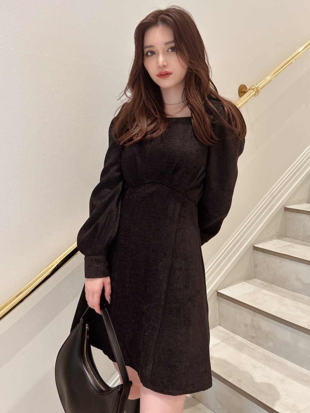 ブラック系のワンピース、ブラック系のハンドバッグを着用したレディースの秋コーディネートの4枚目の写真