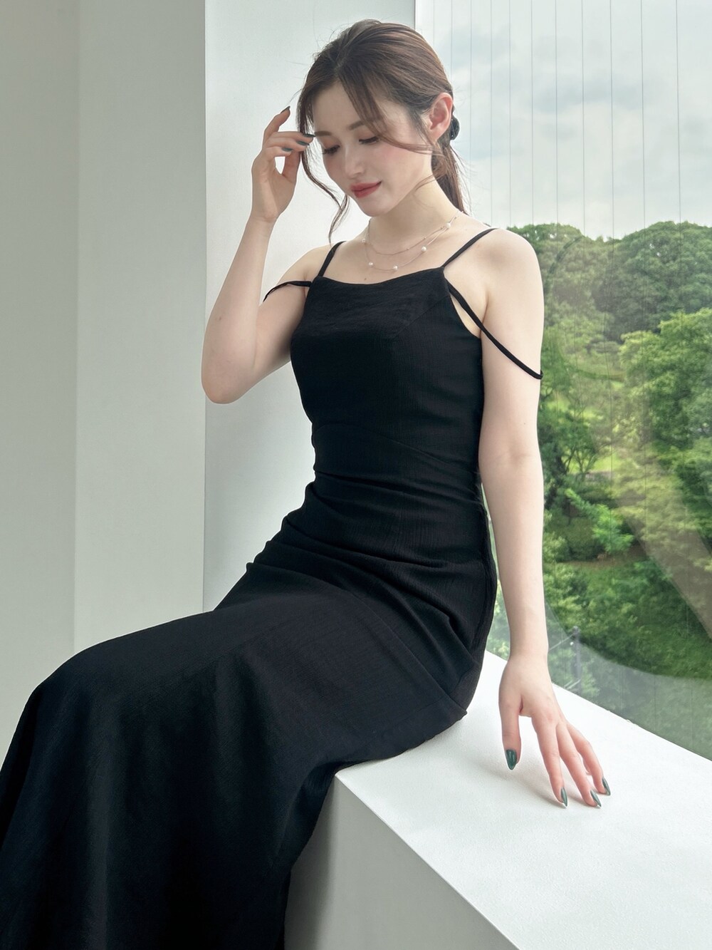 ブラック系のワンピースを着用したレディースの夏コーディネートの2枚目の写真