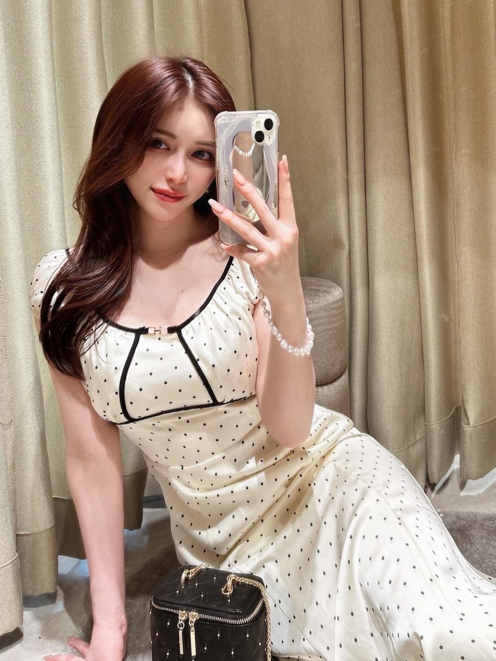 ホワイト系のワンピース、ブラック系のショルダーバッグを着用したレディースの春コーディネートの2枚目の写真