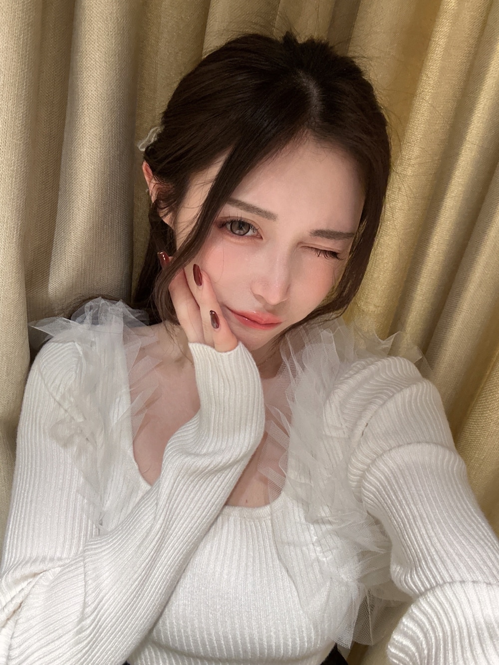 ホワイト系のニット/セーター、ブラック系のスカート、ブラック系のショルダーバッグを着用したレディースの冬コーディネートの2枚目の写真