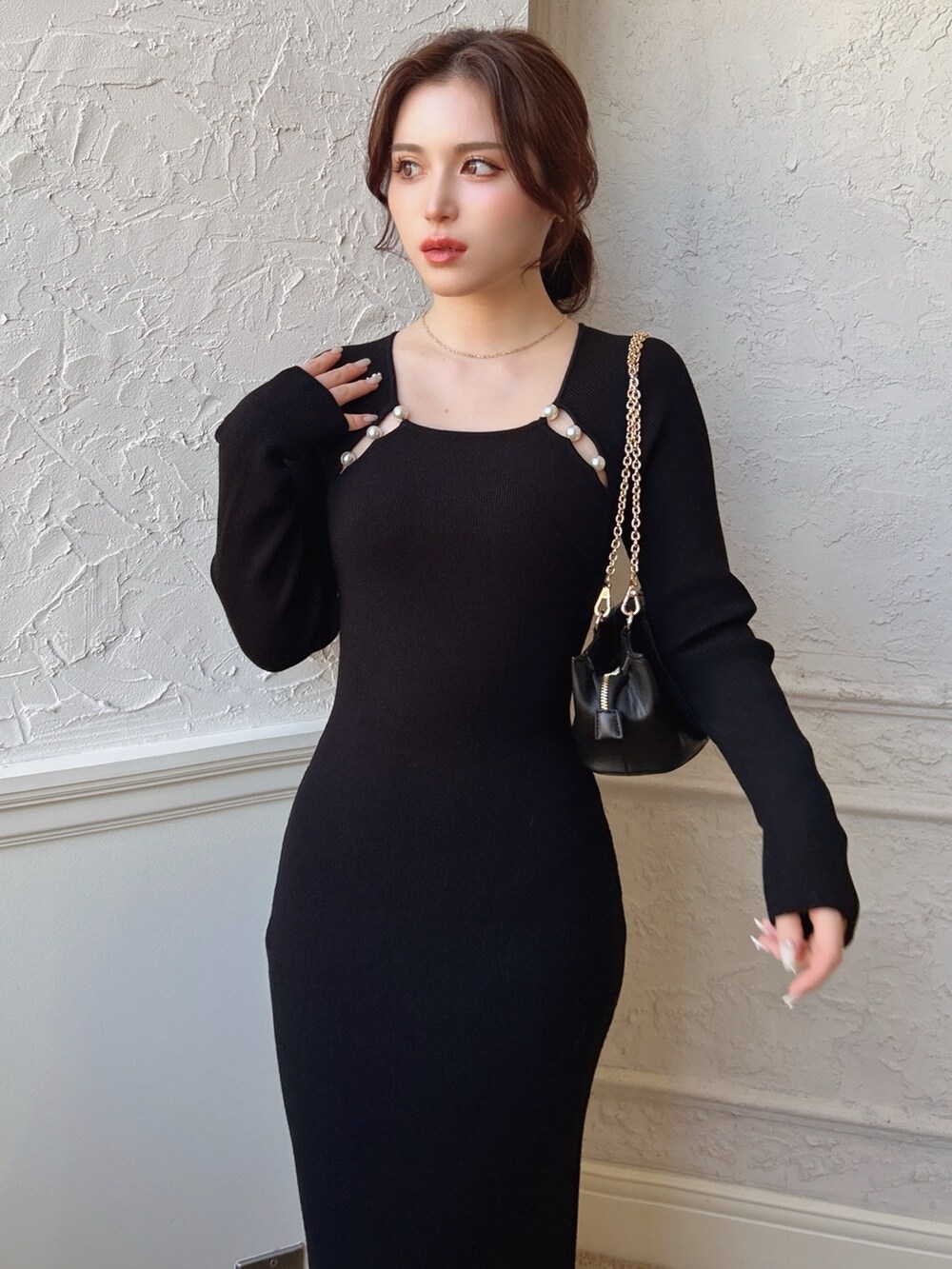 ブラック系のワンピース、ブラック系のハンドバッグを着用したレディースの冬コーディネートの2枚目の写真