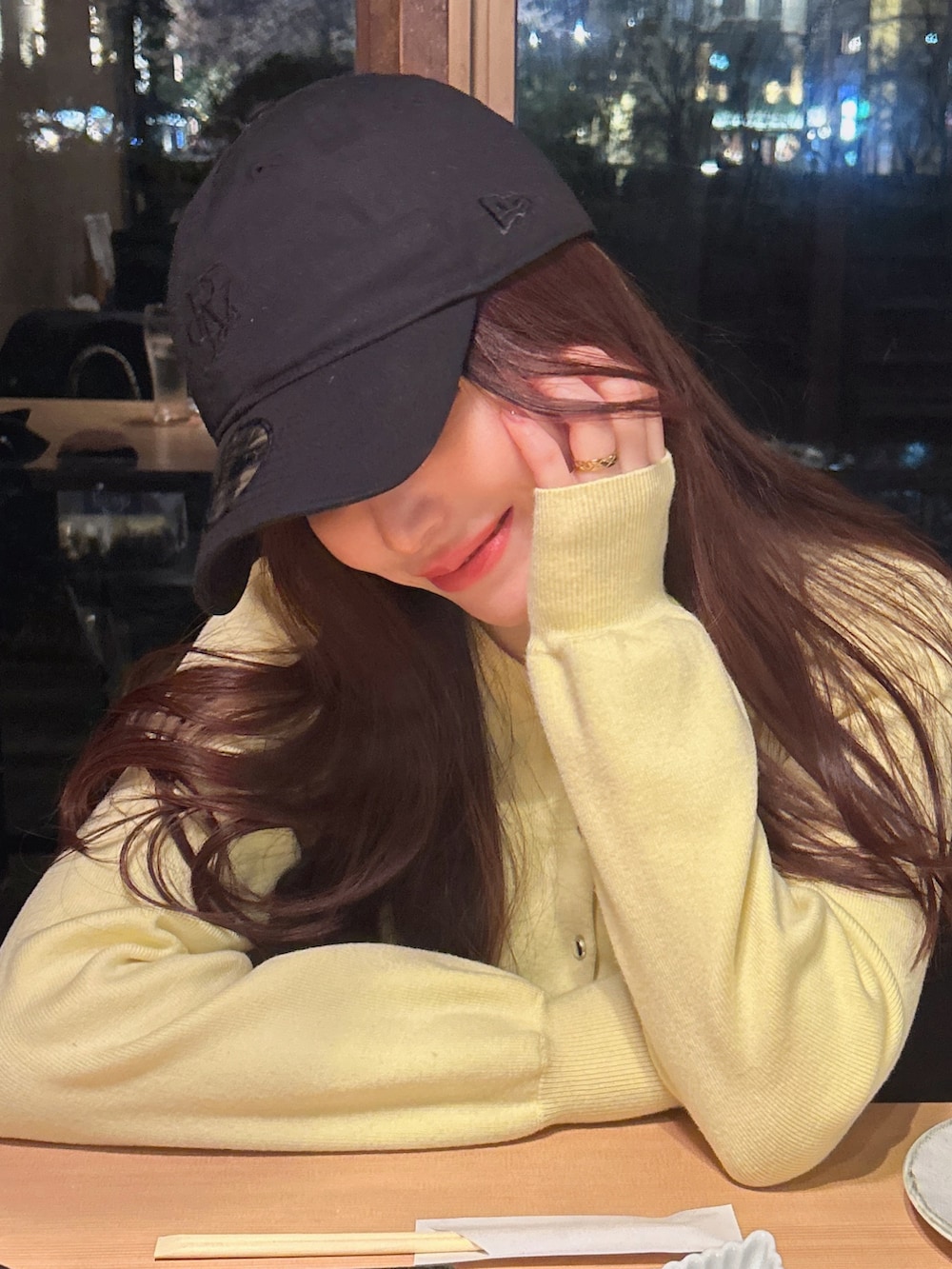 イエロー系のカーディガン/ボレロ、ブラック系のキャップを着用したレディースの春コーディネートの3枚目の写真