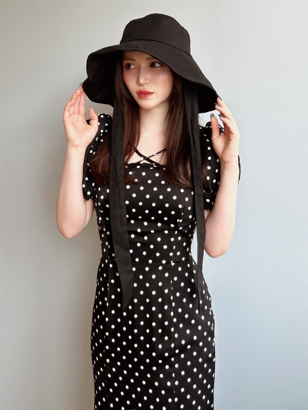 ブラック系のサンダル、ブラック系のワンピース、ブラック系のハットを着用したレディースの夏コーディネートの2枚目の写真