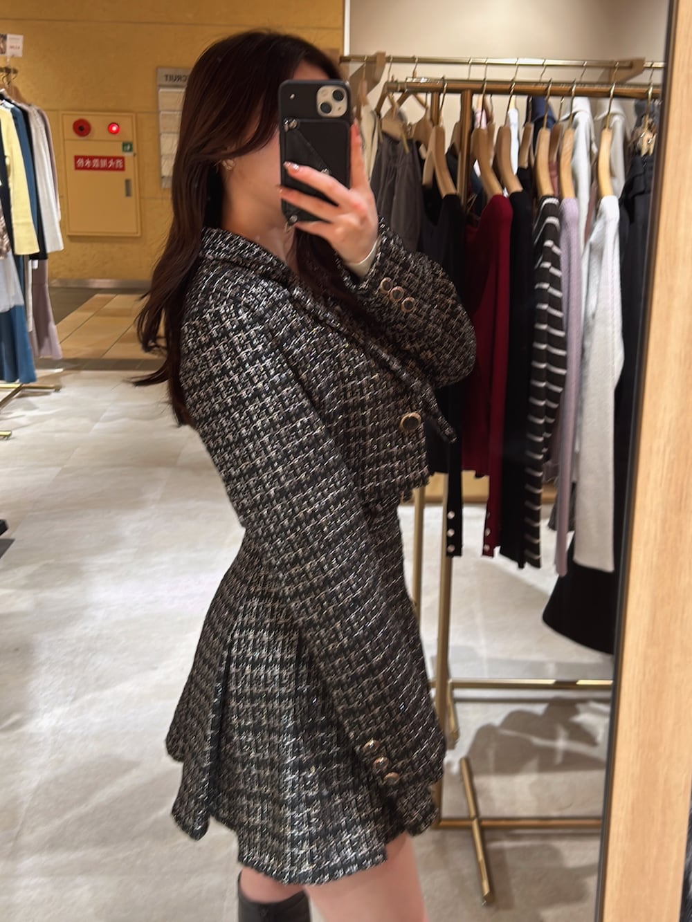 ブラック系のスカート、ブラック系のテーラードジャケット、ホワイト系のニット/セーターを着用したレディースの冬コーディネートの3枚目の写真