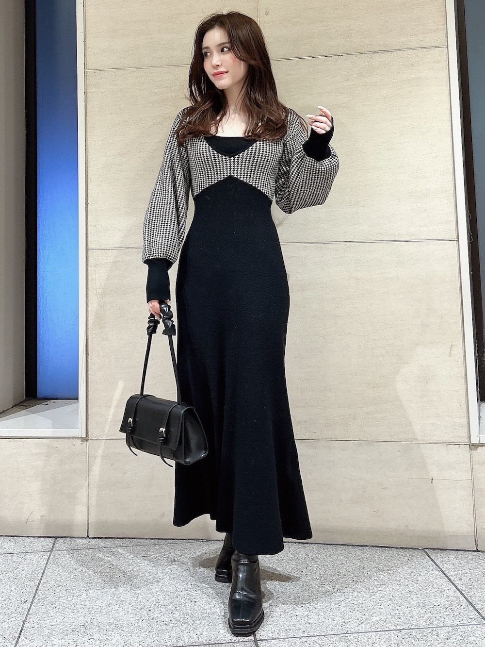 ホワイト系のピーコート、ブラック系のワンピース、ブラック系のハンドバッグを着用したレディースの冬コーディネートの2枚目の写真