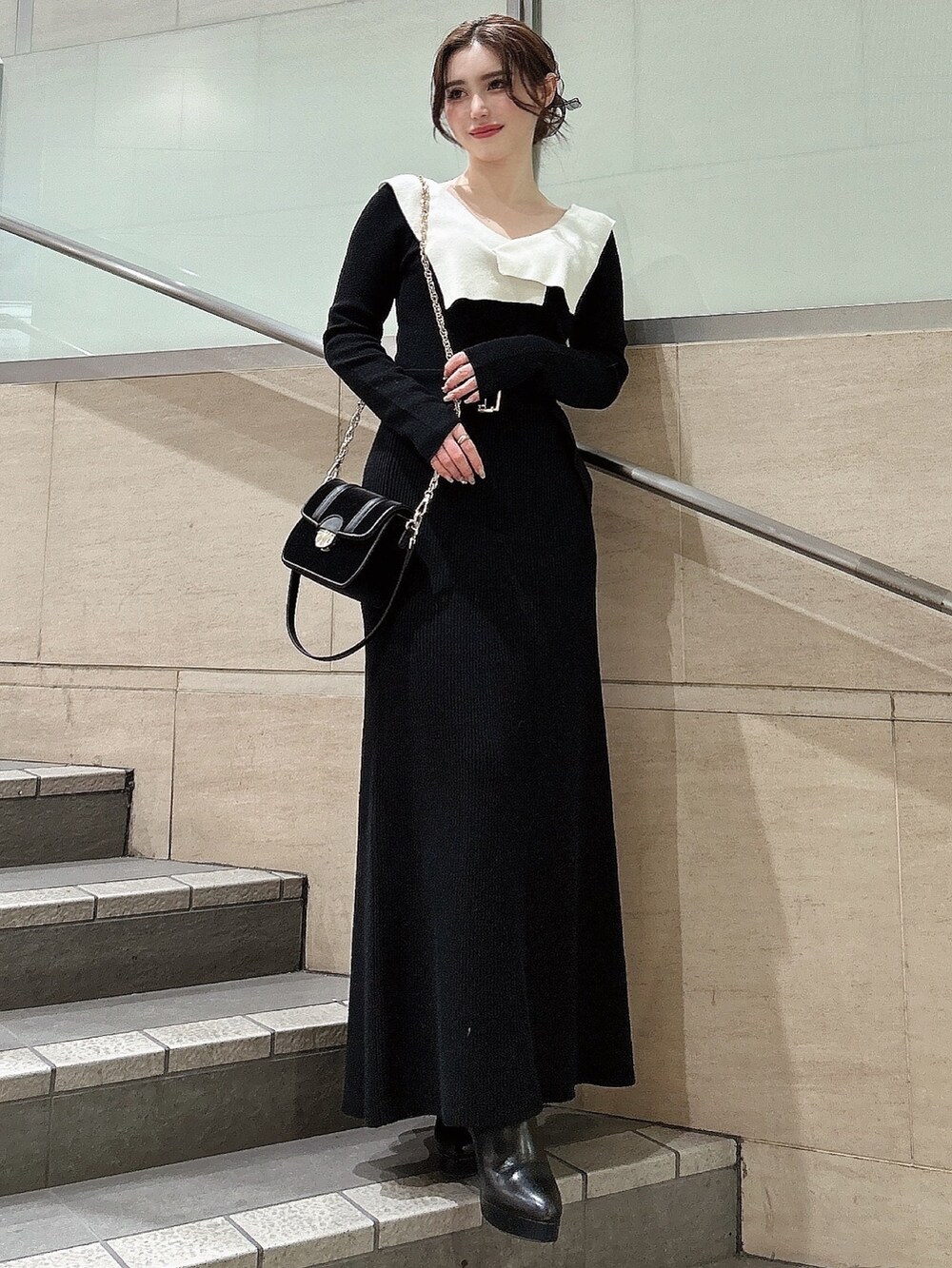 ブラック系のワンピース、ブラック系のブーツ、ブラック系のショルダーバッグを着用したレディースの冬コーディネートの2枚目の写真