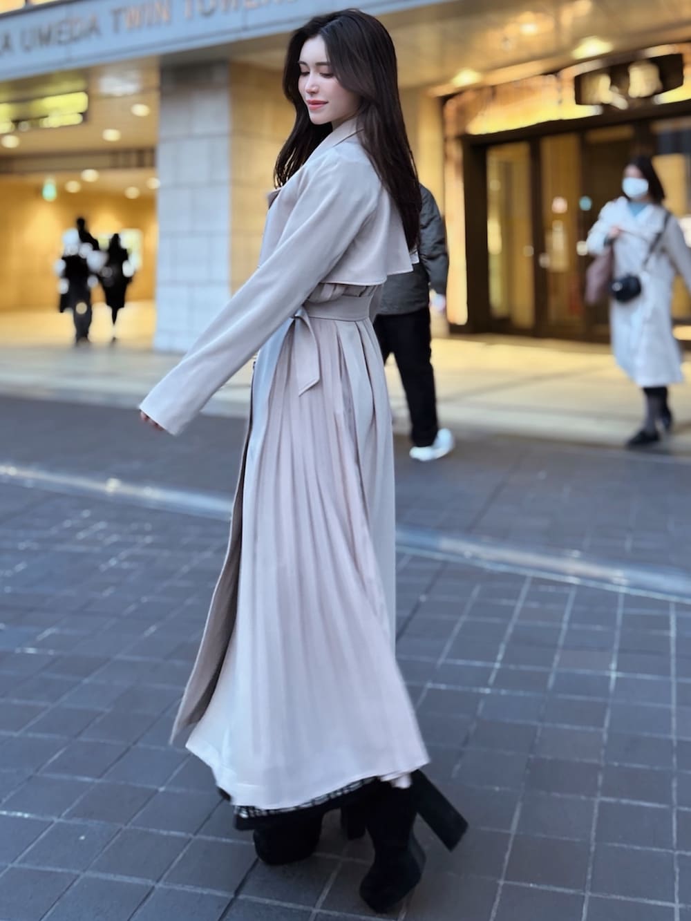 ベージュ系のトレンチコート、ブラック系のハンドバッグを着用したレディースの冬コーディネートの3枚目の写真