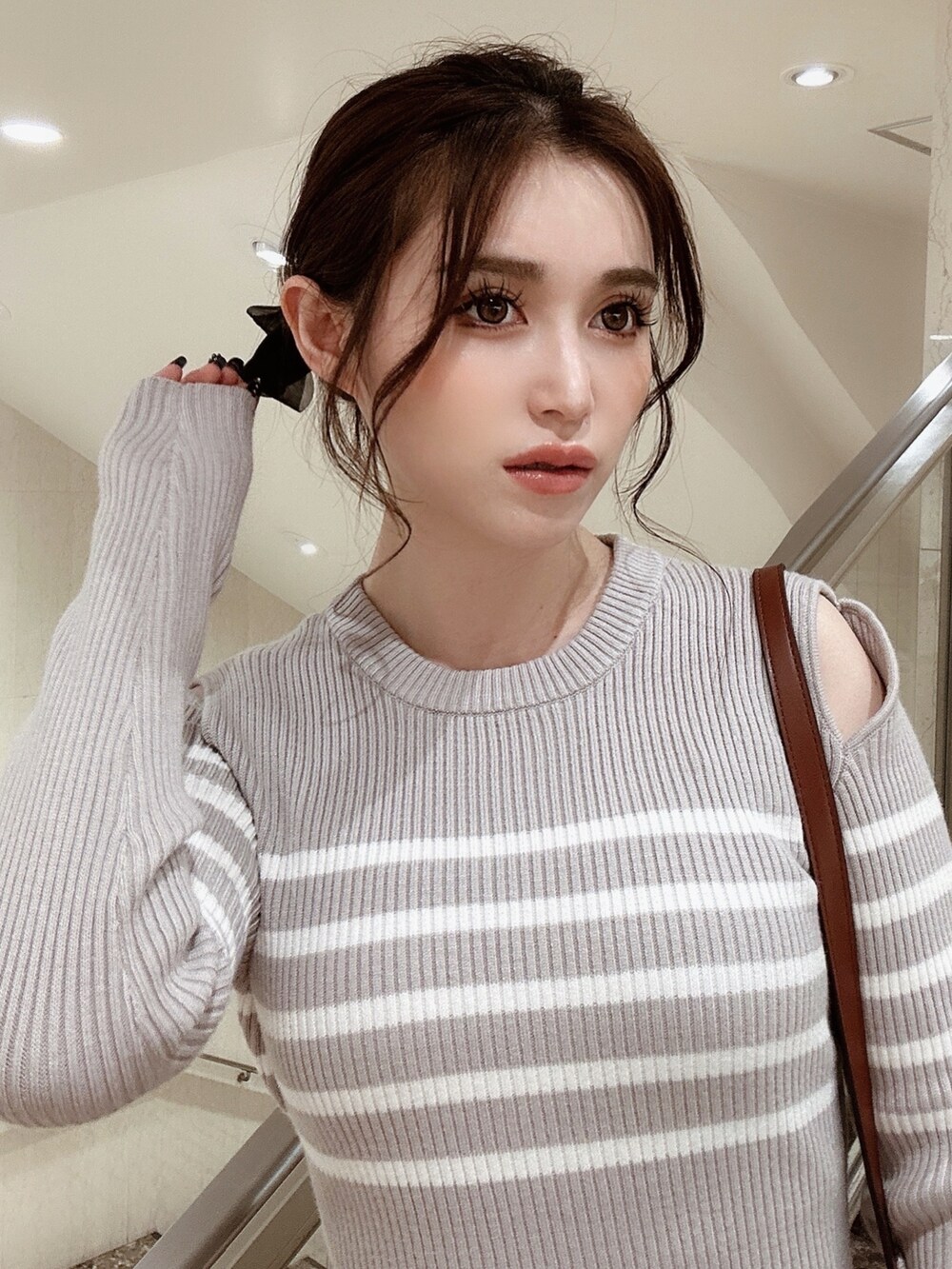 グレー系のワンピース、ブラウン系のブーツ、イエロー系のショルダーバッグを着用したレディースの秋コーディネートの5枚目の写真