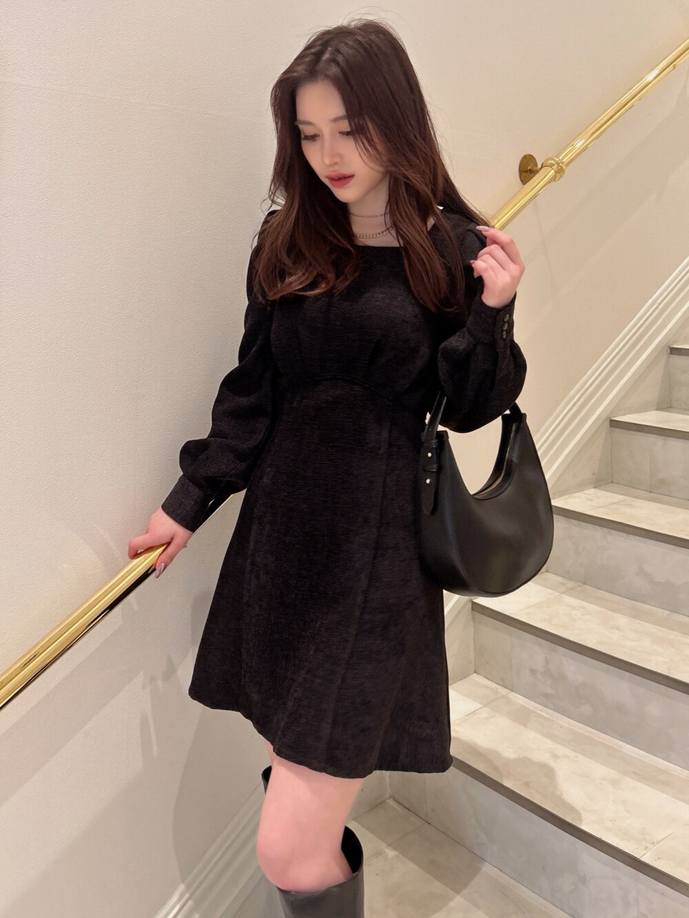 ブラック系のワンピース、ブラック系のハンドバッグを着用したレディースの秋コーディネートの3枚目の写真