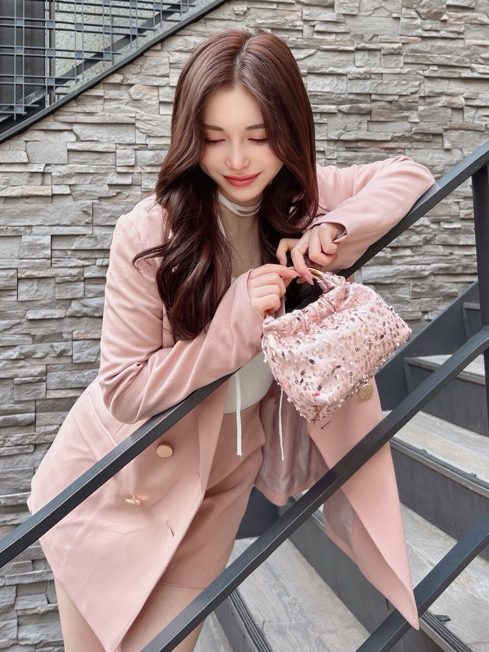 ピンク系のテーラードジャケット、ピンク系のその他パンツ、ホワイト系のニット/セーターを着用したレディースの冬コーディネートの3枚目の写真