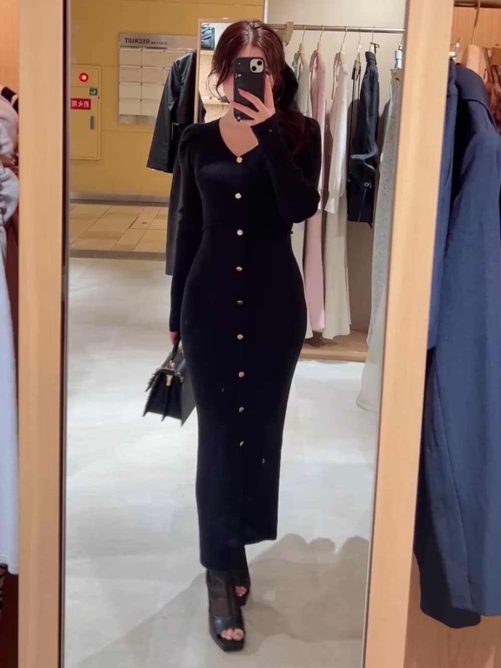 ブラック系のハンドバッグ、ブラック系のワンピースを着用したレディースの冬コーディネートの2枚目の写真