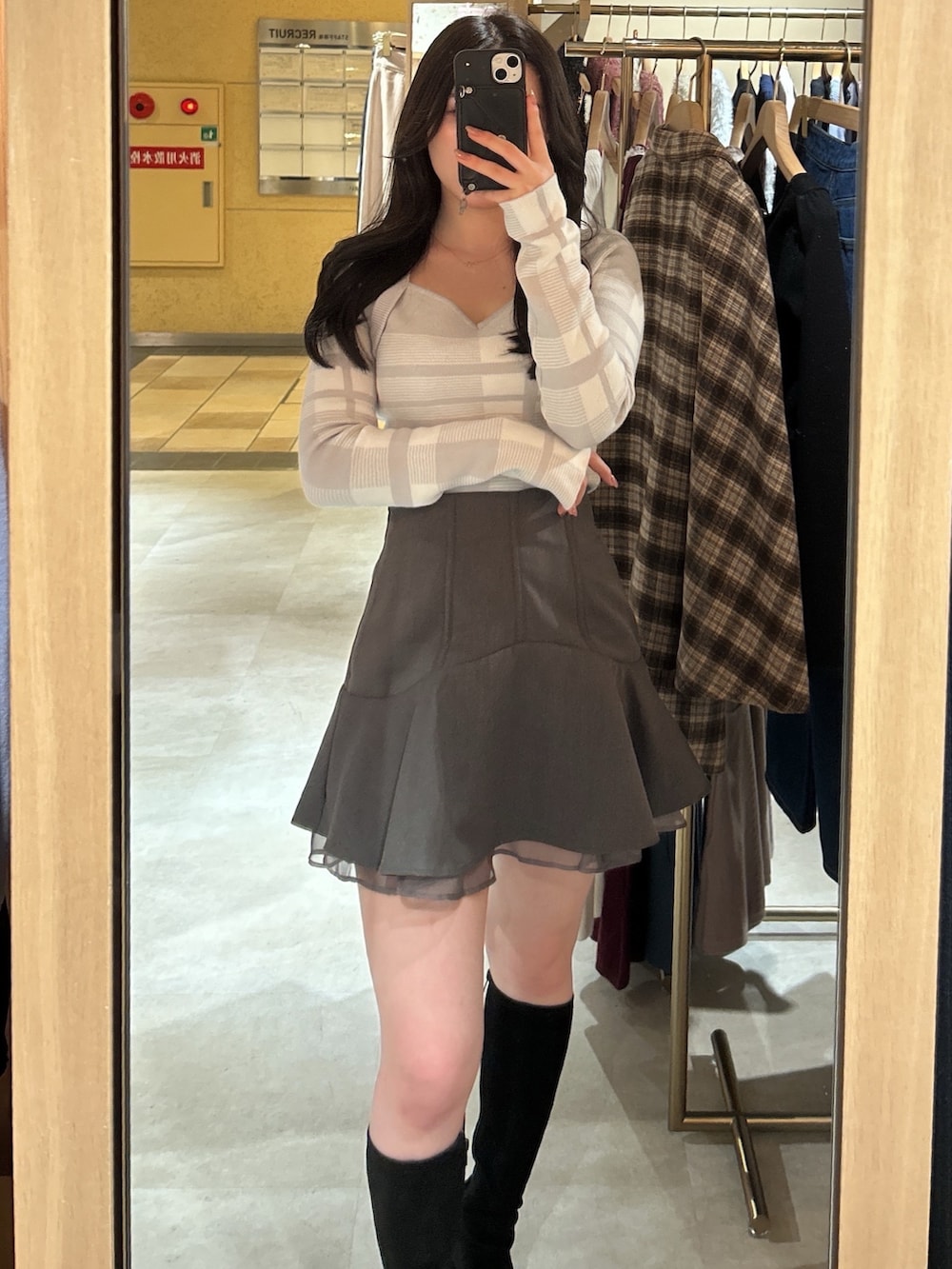 グレー系のニット/セーター、グレー系のスカートを着用したレディースの冬コーディネートの2枚目の写真