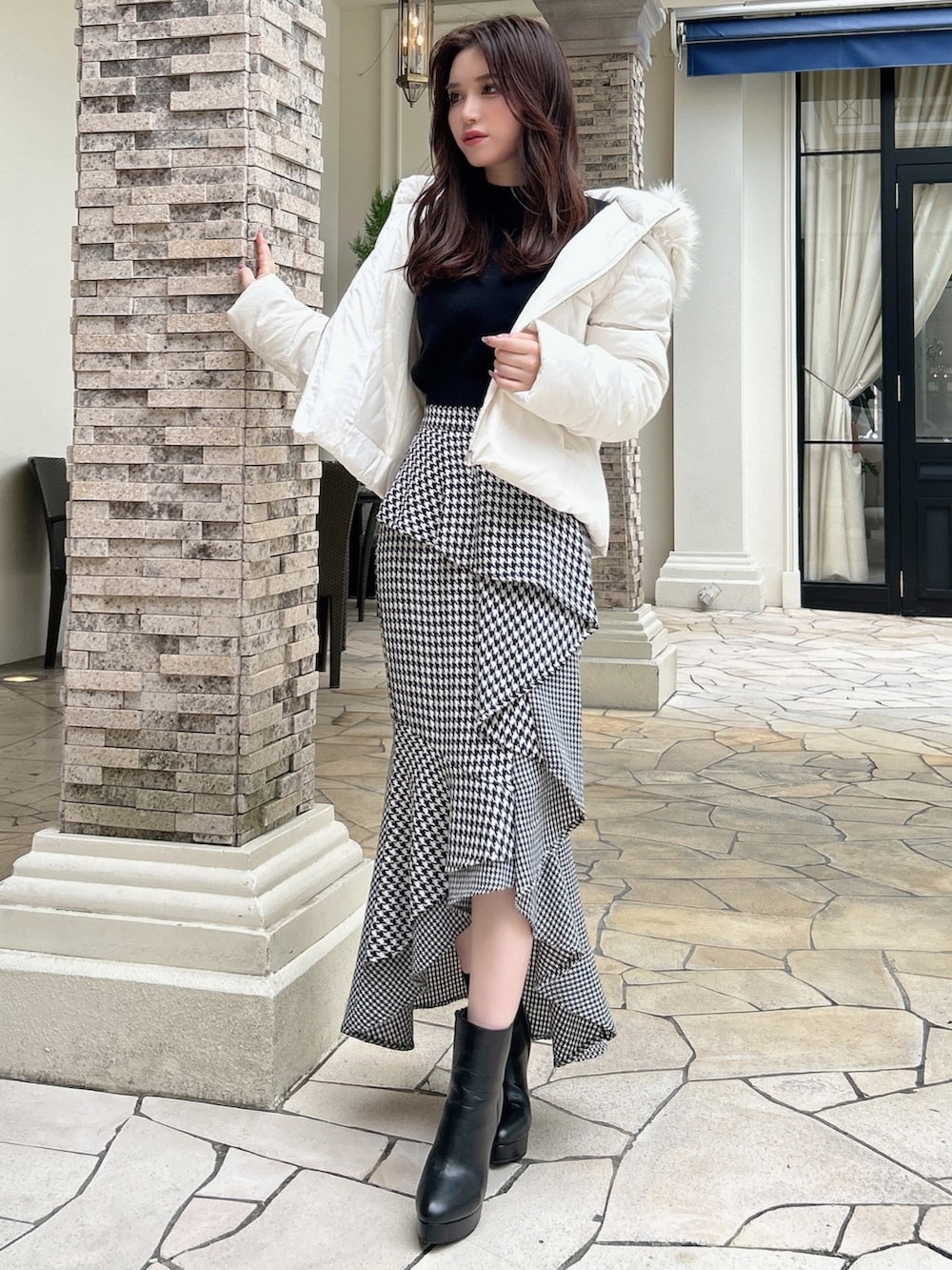 ブラック系のニット/セーター、その他のスカート、ブラック系のブーツを着用したレディースの秋コーディネートの3枚目の写真