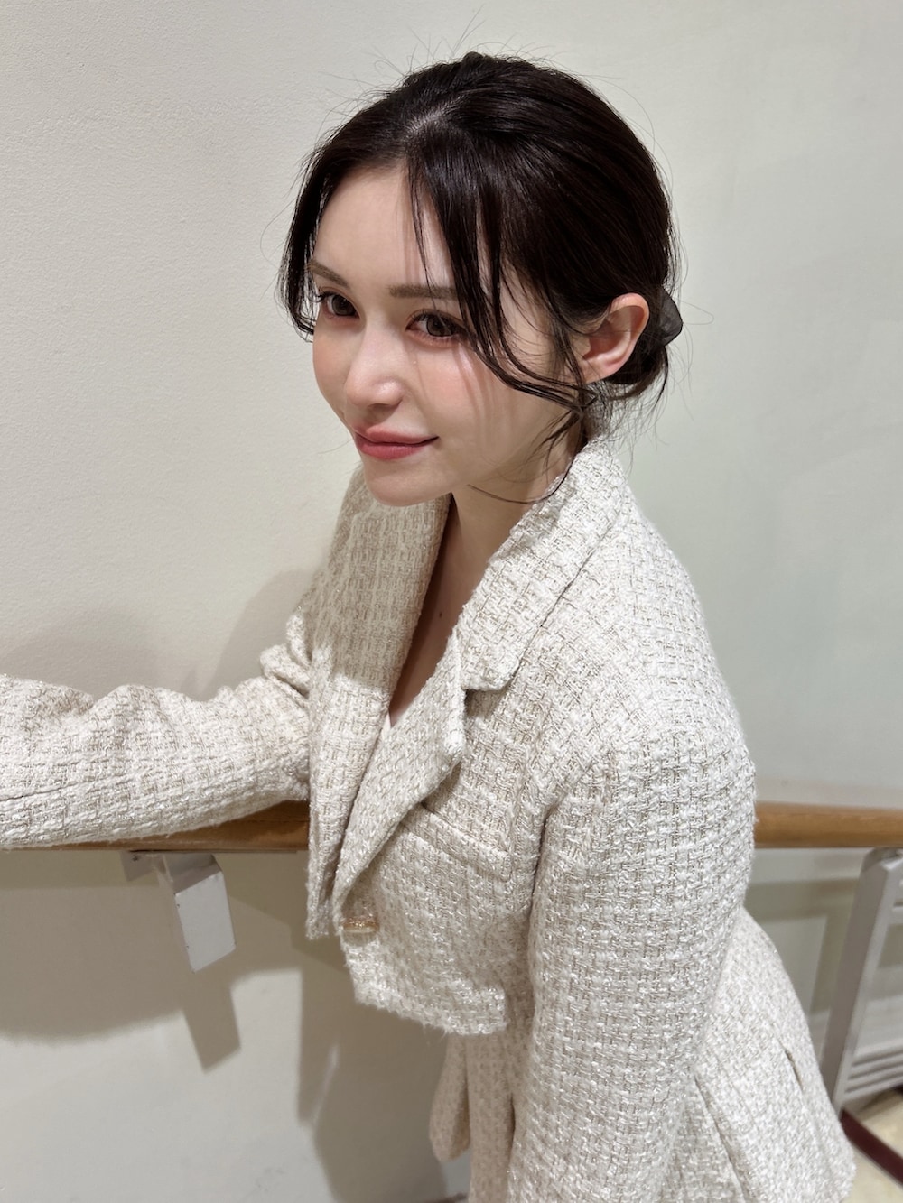 ホワイト系のテーラードジャケット、ホワイト系のキャミソール、ホワイト系のスカートを着用したレディースの冬コーディネートの2枚目の写真