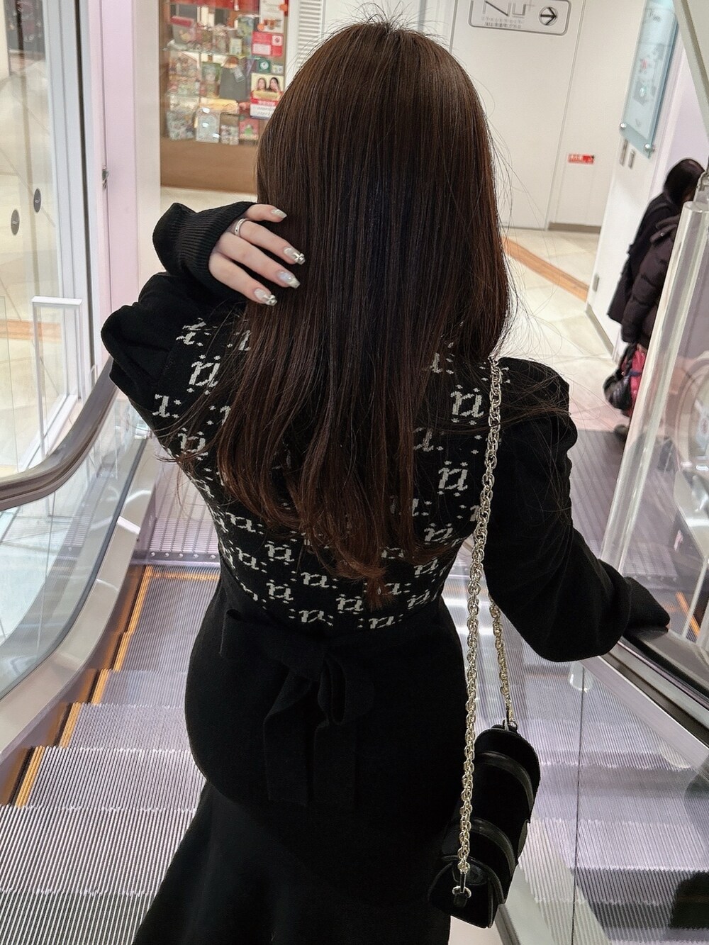 ブラック系のワンピース、ブラック系のショルダーバッグ、ブラック系のハットを着用したレディースの冬コーディネートの3枚目の写真