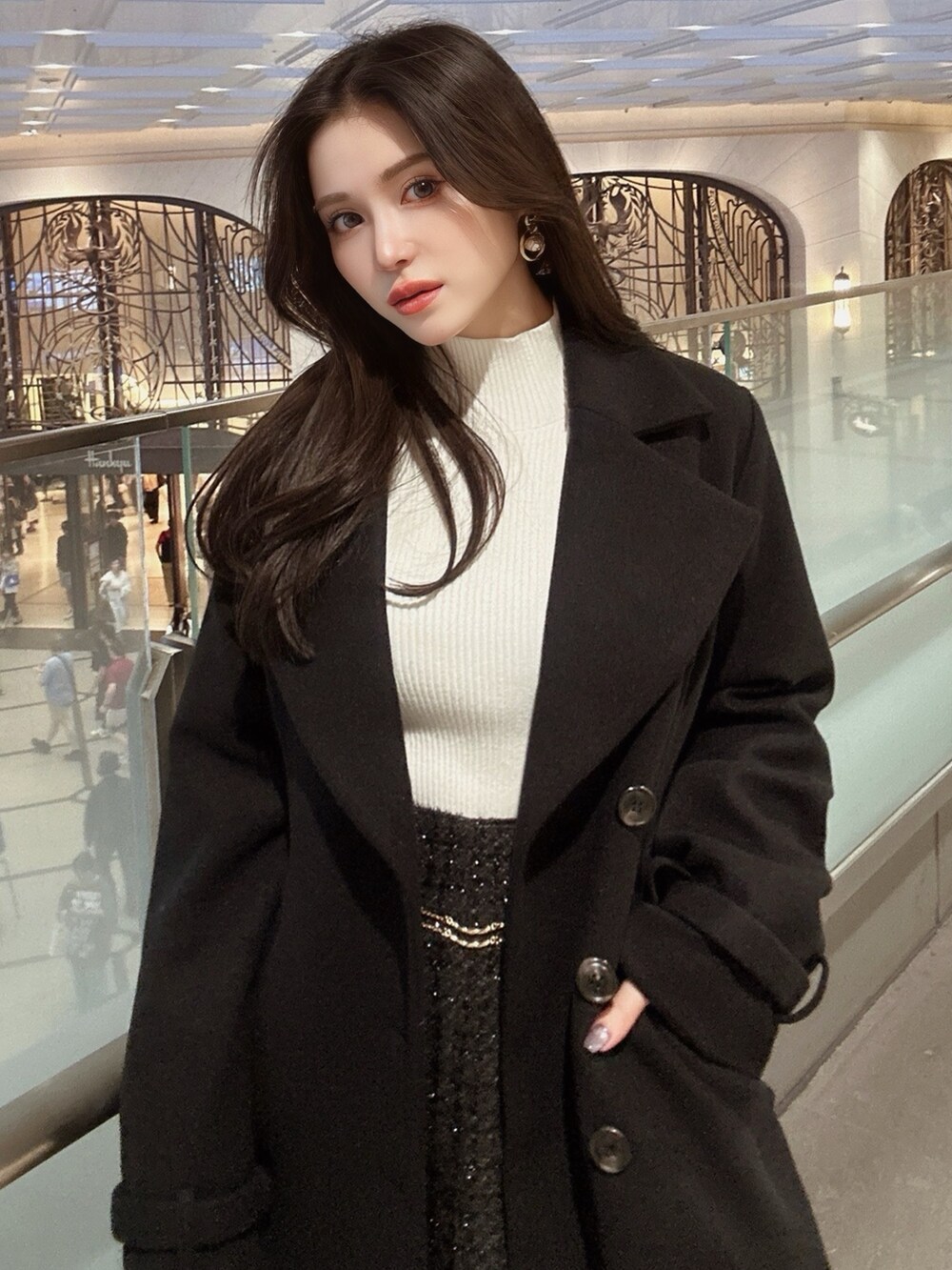 ブラック系のその他アウター、ブラック系のスカート、ホワイト系のニット/セーターを着用したレディースの秋コーディネートの5枚目の写真