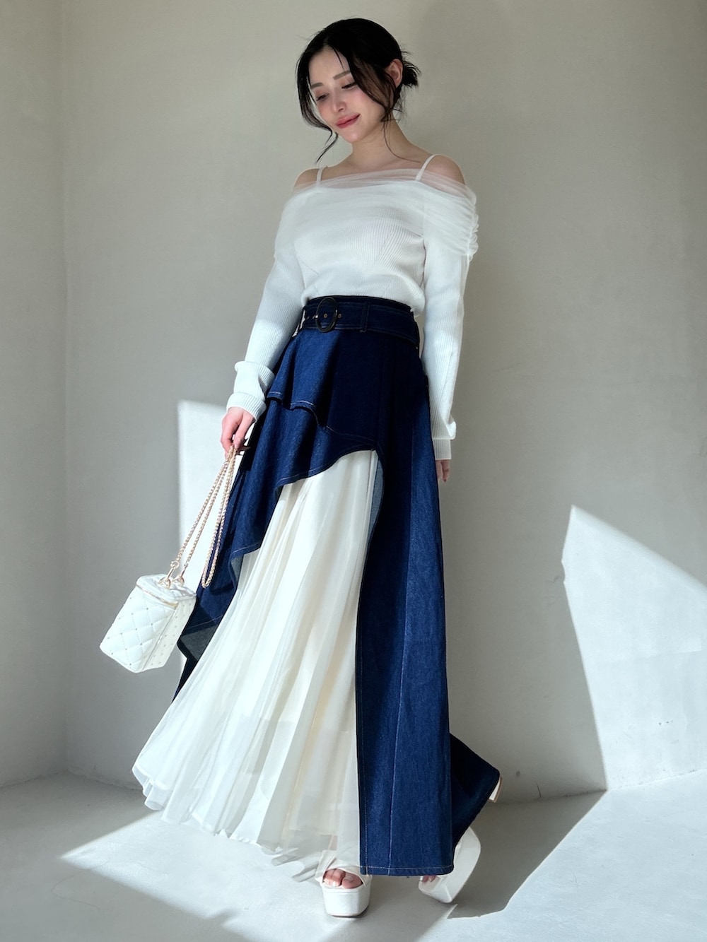 ピンク系のニット/セーター、ブルー系のスカートを着用したレディースの冬コーディネートの3枚目の写真