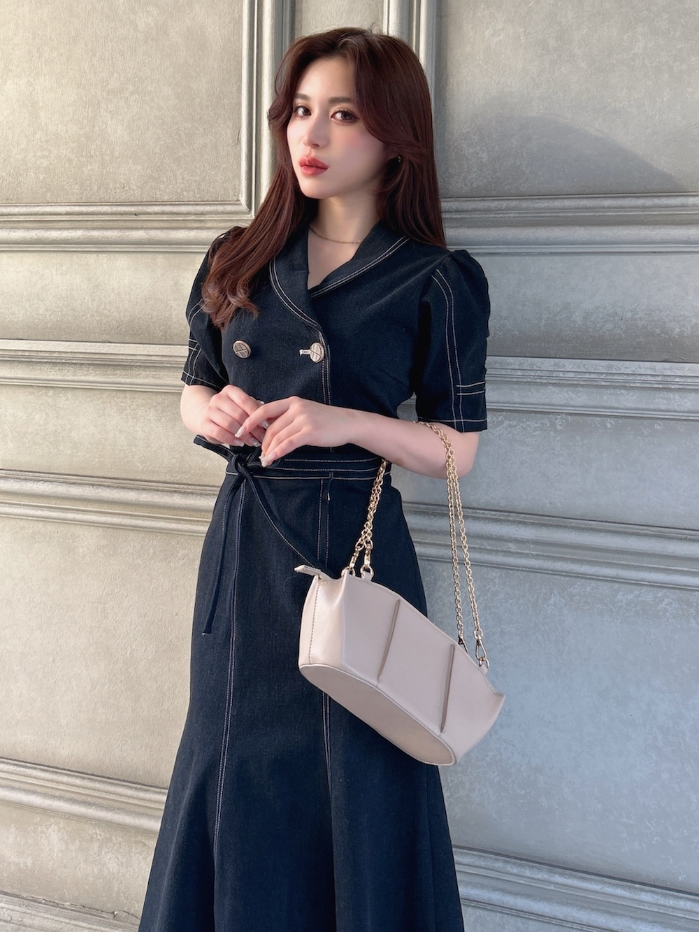 ブルー系のワンピース、ベージュ系のハンドバッグ、ホワイト系のパンプスを着用したレディースの春コーディネートの3枚目の写真