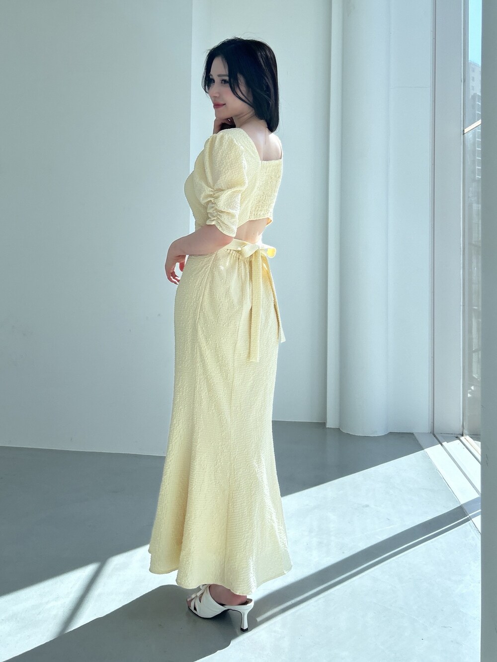 イエロー系のワンピースを着用したレディースの冬コーディネートの3枚目の写真