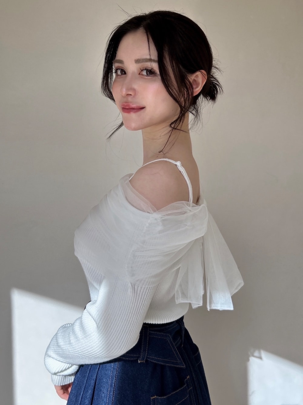 ピンク系のニット/セーター、ブルー系のスカートを着用したレディースの冬コーディネートの2枚目の写真