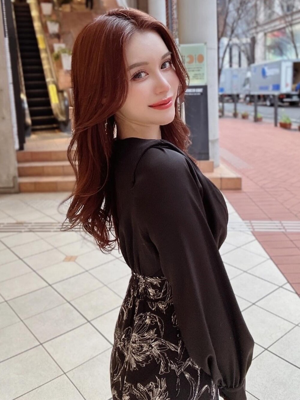 ブラック系のワンピース、ホワイト系のハンドバッグ、ホワイト系のパンプスを着用したレディースの冬コーディネートの2枚目の写真