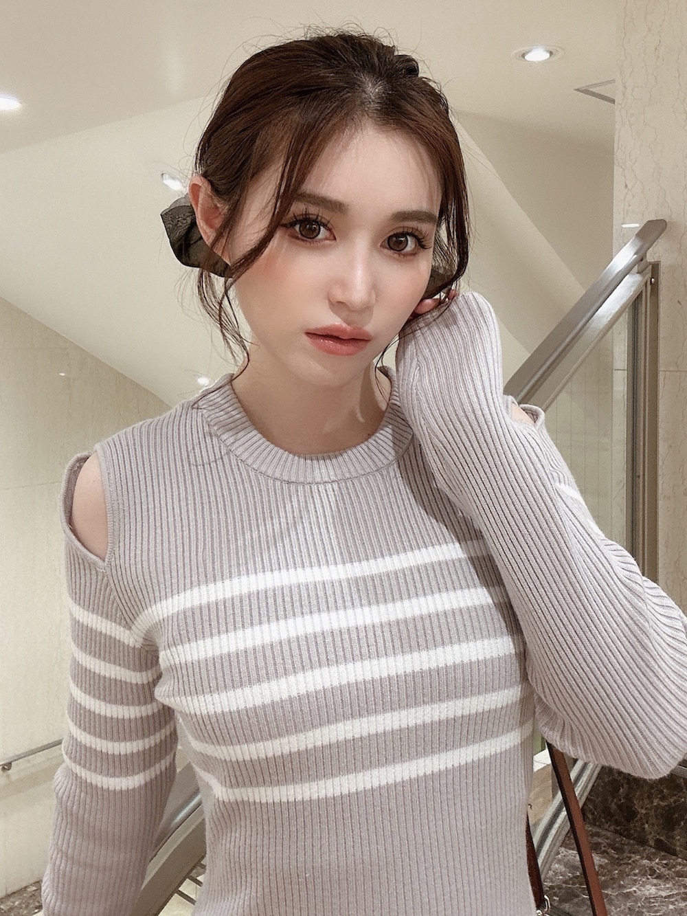 グレー系のワンピース、ブラウン系のブーツ、イエロー系のショルダーバッグを着用したレディースの秋コーディネートの4枚目の写真