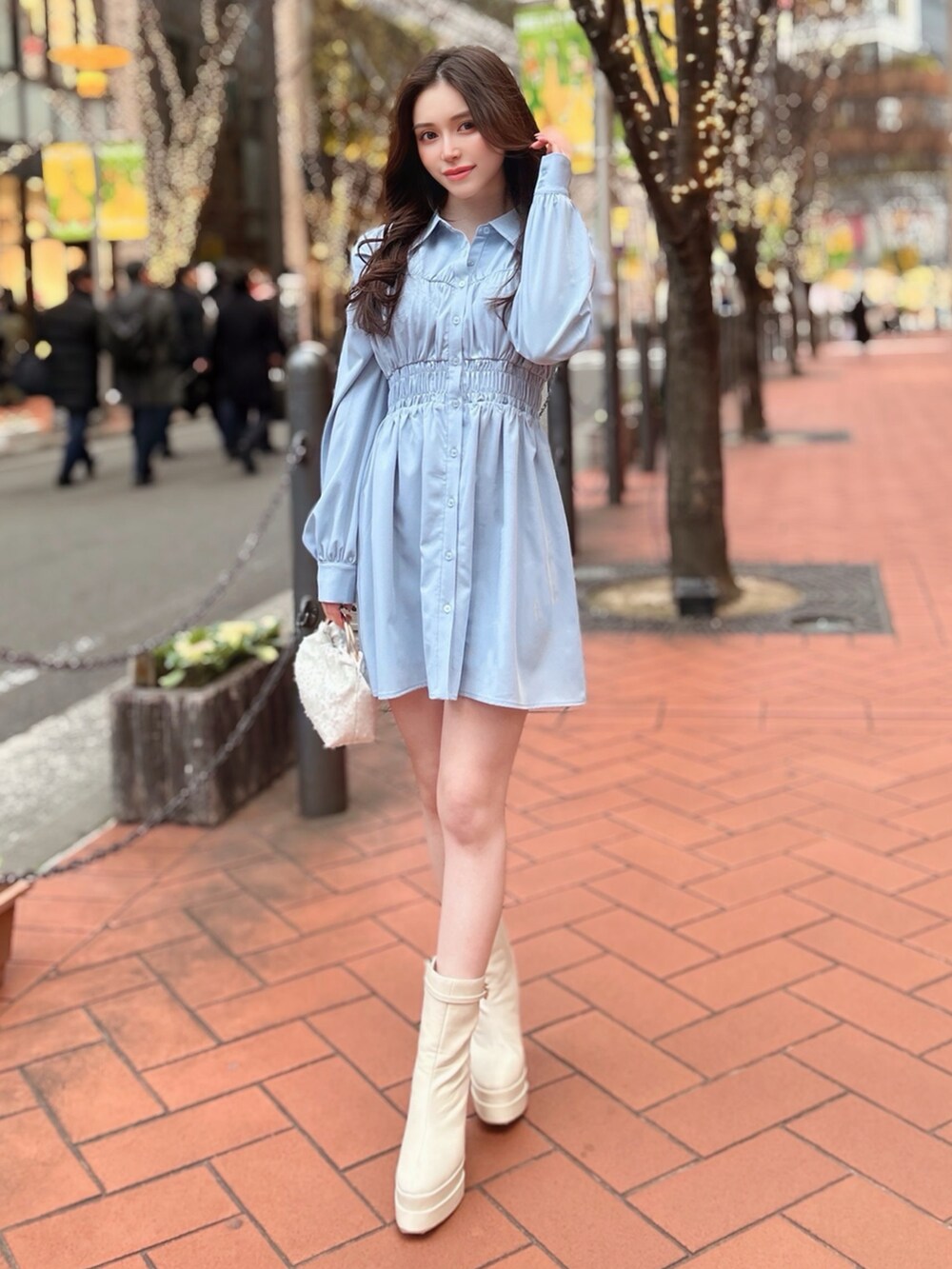 ブルー系のワンピース、ホワイト系のブーツを着用したレディースの冬コーディネートの2枚目の写真