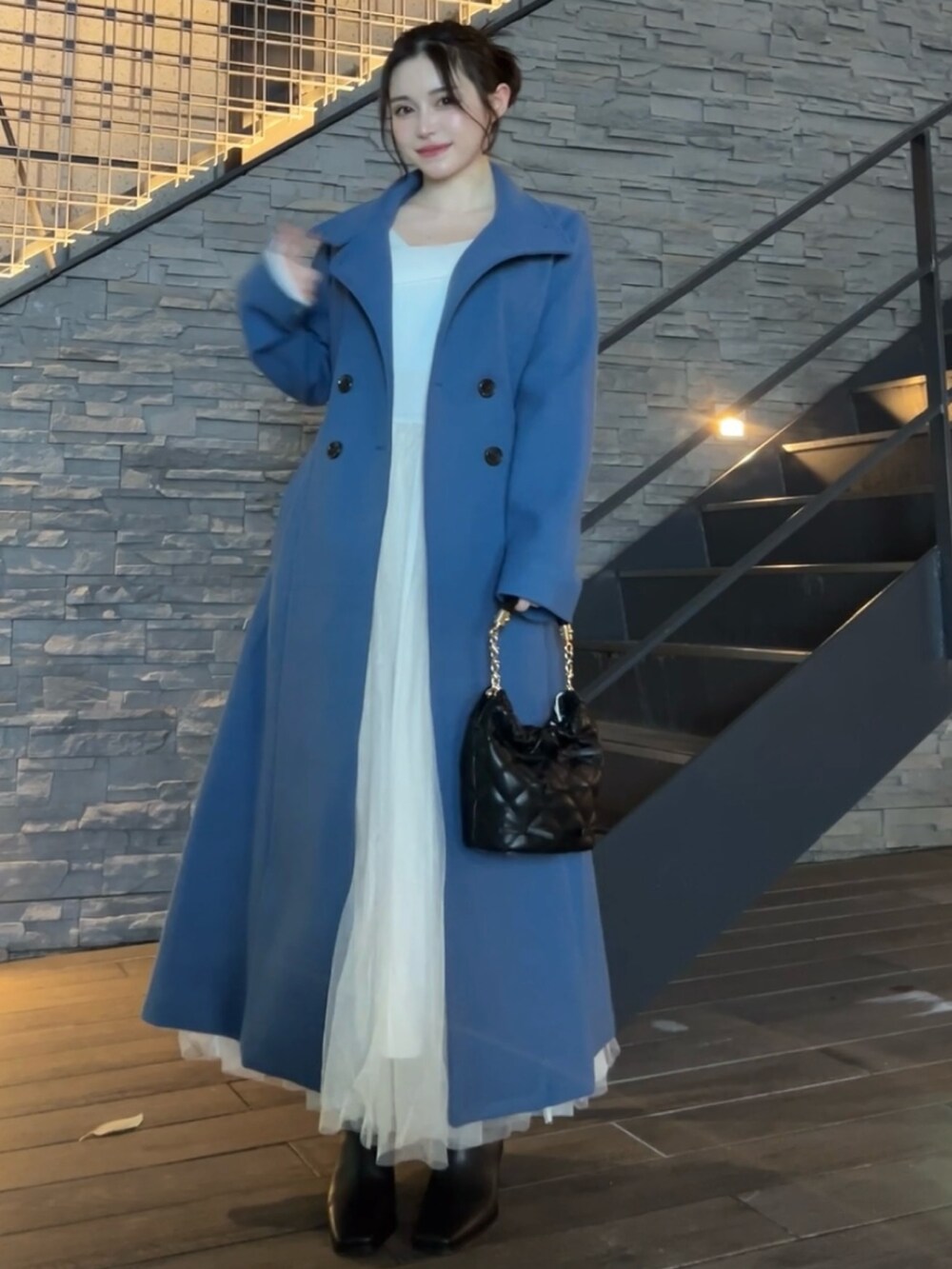 ブルー系のその他アウター、ブラック系のハンドバッグ、ブラック系のブーツを着用したレディースの秋コーディネートの2枚目の写真