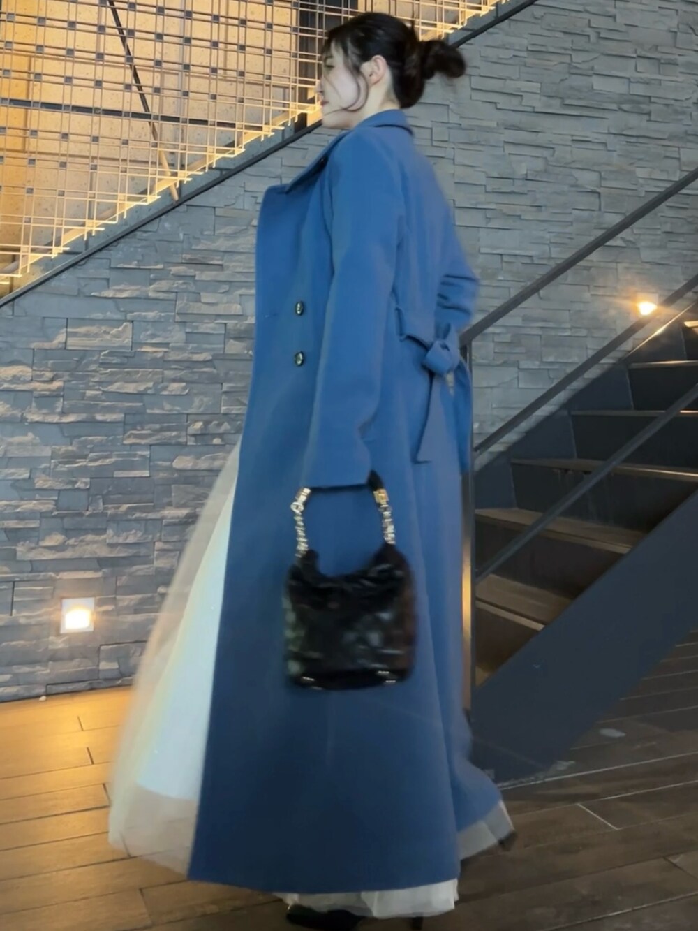 ブルー系のその他アウター、ブラック系のハンドバッグ、ブラック系のブーツを着用したレディースの秋コーディネートの3枚目の写真