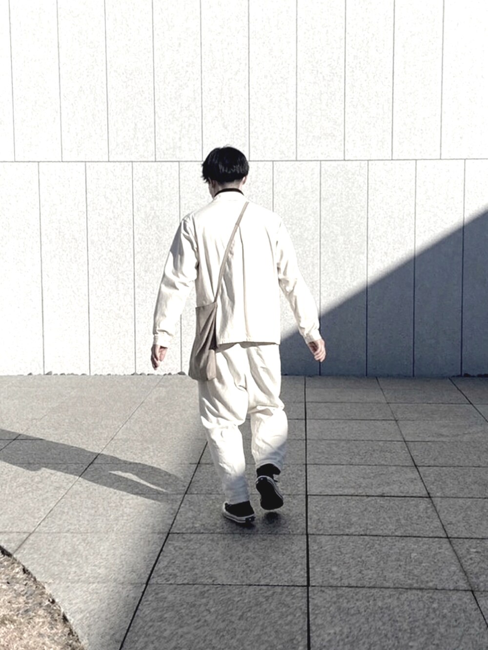 ブラック系のスニーカー、ホワイト系のその他パンツ、グレー系のショルダーバッグを着用したメンズの冬コーディネートの3枚目の写真