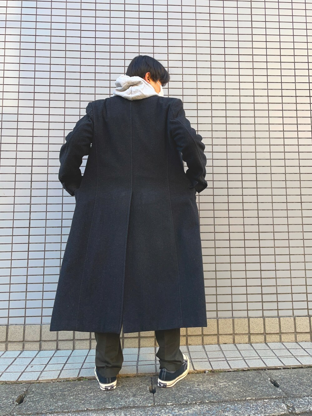 ブラック系のスニーカー、グリーン系のスラックス、グレー系のパーカーを着用したメンズの冬コーディネートの3枚目の写真