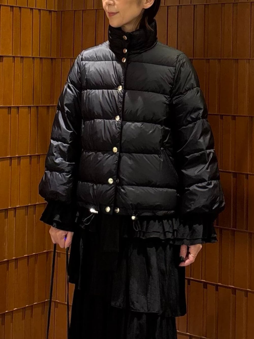 ブラック系のブーツ、ブラック系のダウンジャケット/コート、ブラック系のシャツ/ブラウスを着用したレディースの秋コーディネートの4枚目の写真