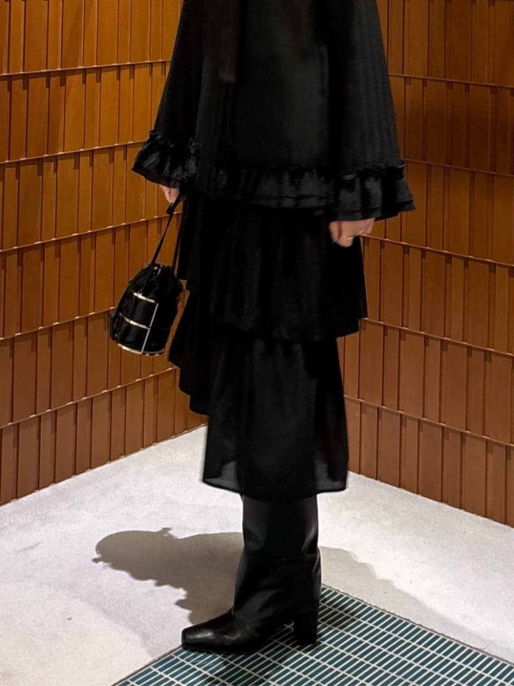 ブラック系のブーツ、ブラック系のダウンジャケット/コート、ブラック系のシャツ/ブラウスを着用したレディースの秋コーディネートの3枚目の写真