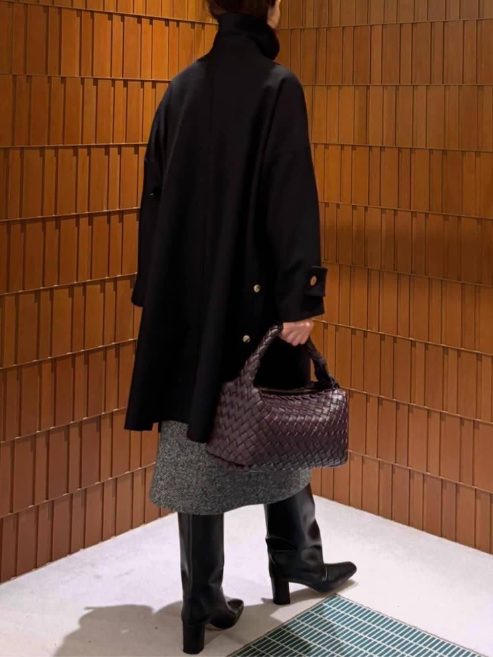 ブラック系のブーツ、ブラック系のステンカラーコート、ブラック系のニット/セーターを着用したレディースの秋コーディネートの4枚目の写真