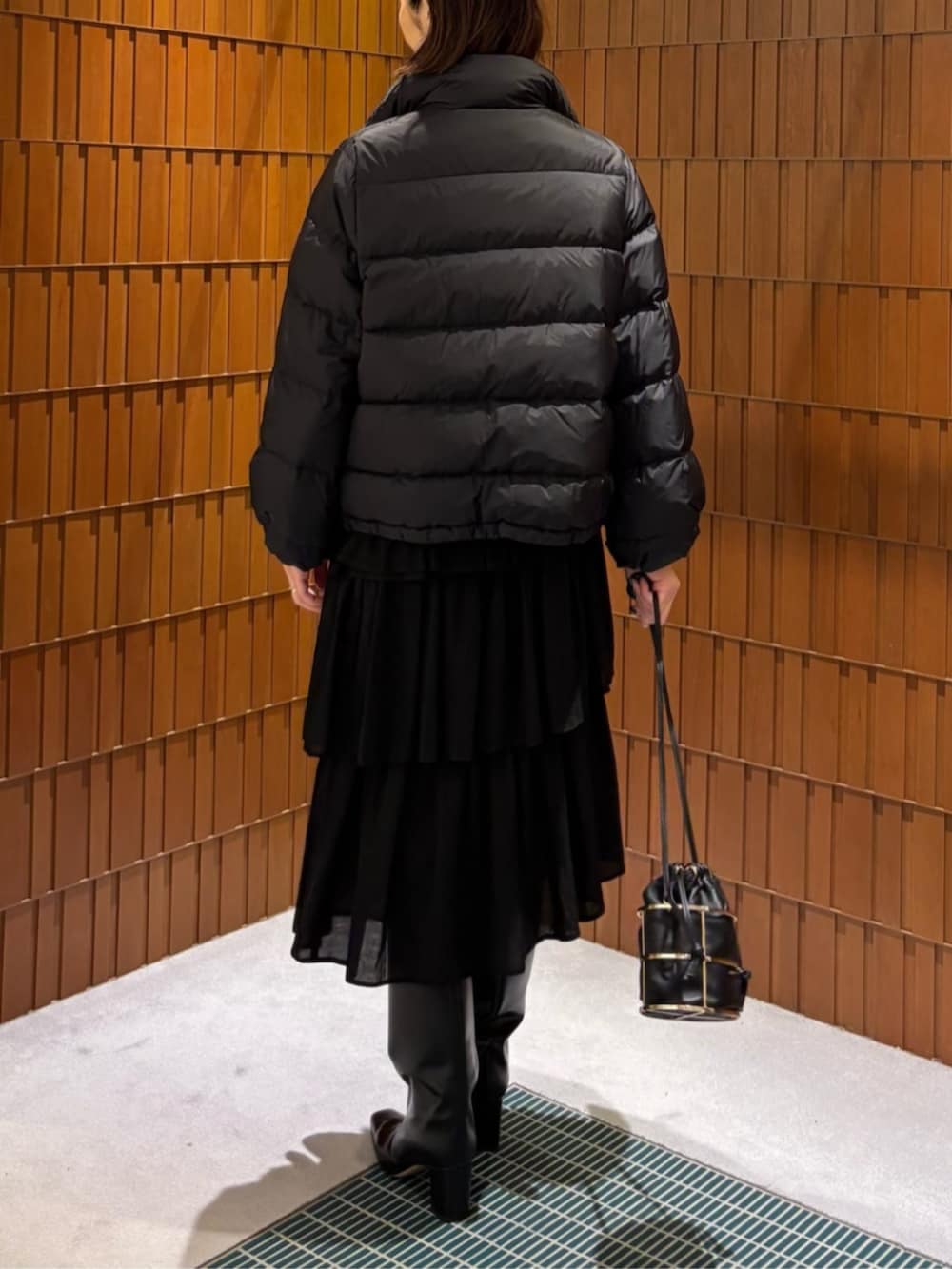 ブラック系のブーツ、ブラック系のダウンジャケット/コート、ブラック系のシャツ/ブラウスを着用したレディースの秋コーディネートの6枚目の写真