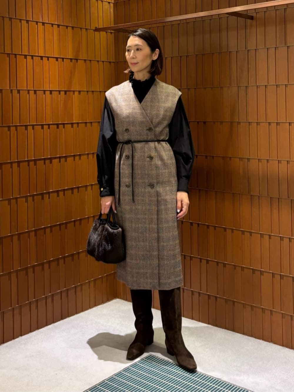 ブラウン系のブーツ、ブラウン系のピーコート、ブラウン系のワンピースを着用したレディースの秋コーディネートの2枚目の写真