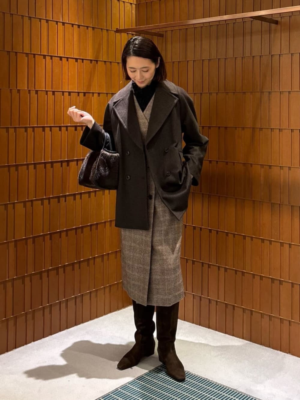 ブラウン系のブーツ、ブラウン系のピーコート、ブラウン系のワンピースを着用したレディースの秋コーディネートの5枚目の写真